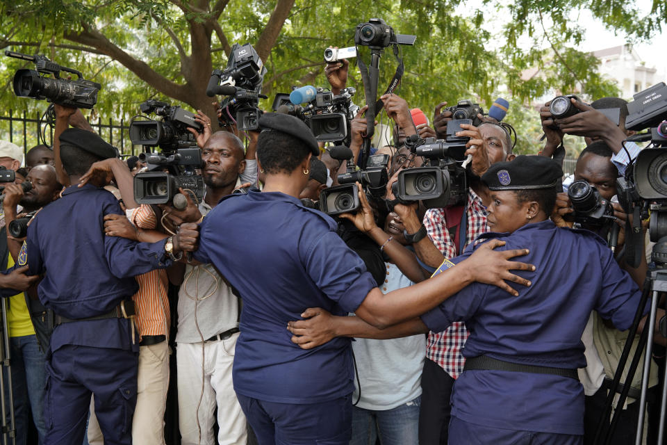 Congolese police officers hold back members of the media as Congo opposition candidate Martin Fayulu leaves the constitution court in Kinshasa, Congo, Saturday Jan. 12, 2019. The ruling coalition of Congo's outgoing President Joseph Kabila has won a large majority of national assembly seats, the electoral commission announced Saturday, while the presidential election runner-up was poised to file a court challenge alleging fraud. (AP Photo/Jerome Delay)