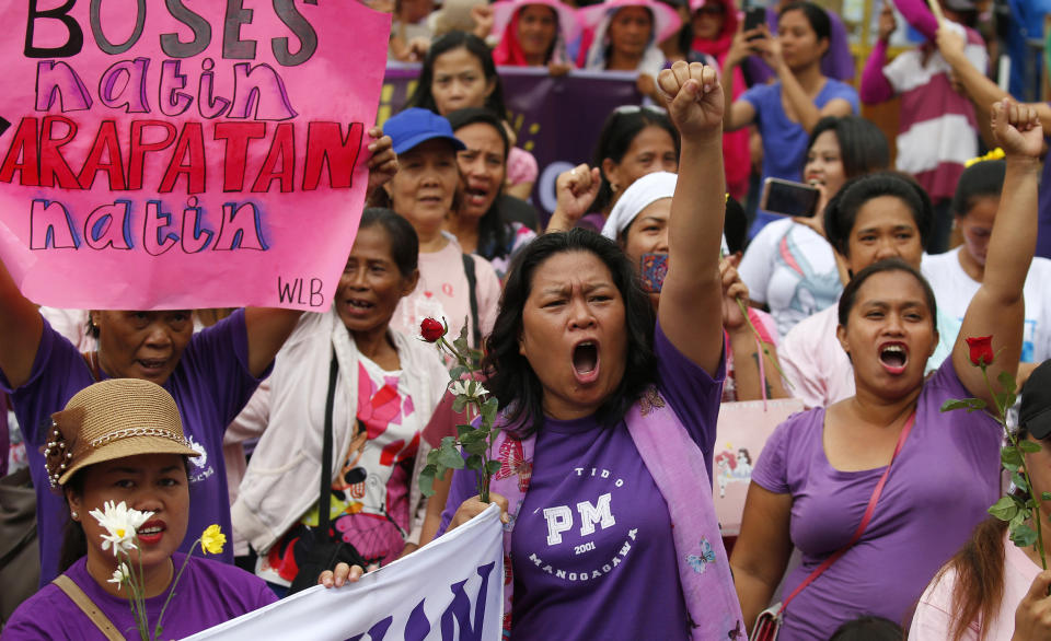 FILE - In this March 8, 2018, file photo, women protesters shout slogans during a rally to mark International Women's Day which largely turns out to be an anti-government event in Manila, Philippines. The Philippine president signed Tuesday, July 26, 2019, a bill into law penalizing a range of acts of sexual harassment including catcalling, wolf-whistling and persistent telling of sexual jokes, which pro-women's groups have accused him of committing. The placard reads: "Our Voice, Our Rights." (AP Photo/Bullit Marquez, File)