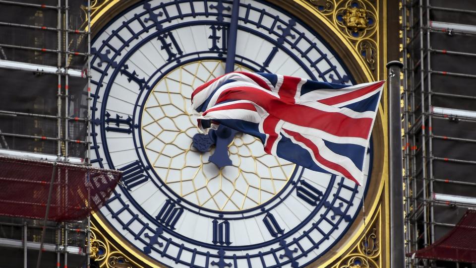Eine am Ziffernblatt des Big Ben befestigte britische Flagge weht im Wind.