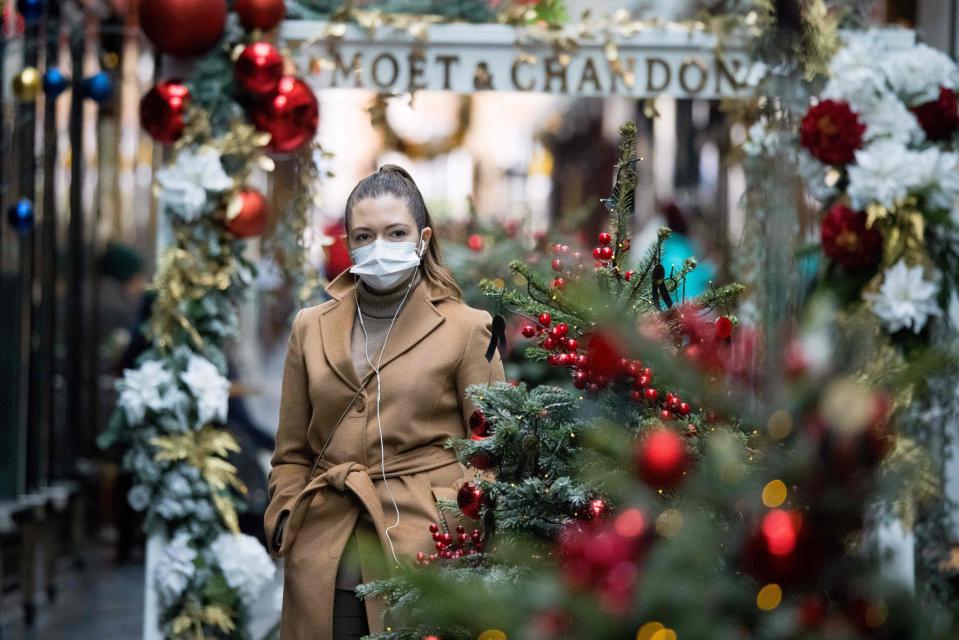 A pedestrian wearing a face mask due to the COVID-19 pandemic, walks past Christmas-themed window displays inside Burlington Arcade in central London, on November 23, 2020. - Prime Minister Boris Johnson's latest plan is to roll out mass testing to the hardest-hit areas, hoping to make enough inroads to be able to relax social restrictions in time for Christmas. (Photo by Tolga Akmen / AFP) (Photo by TOLGA AKMEN/AFP via Getty Images)