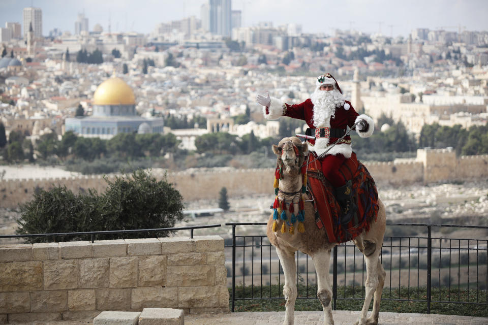 Palestinian Issa Kassissieh, dressed as Santa, rides a camel at the Mount of Olives in Jerusalem on Dec. 6.