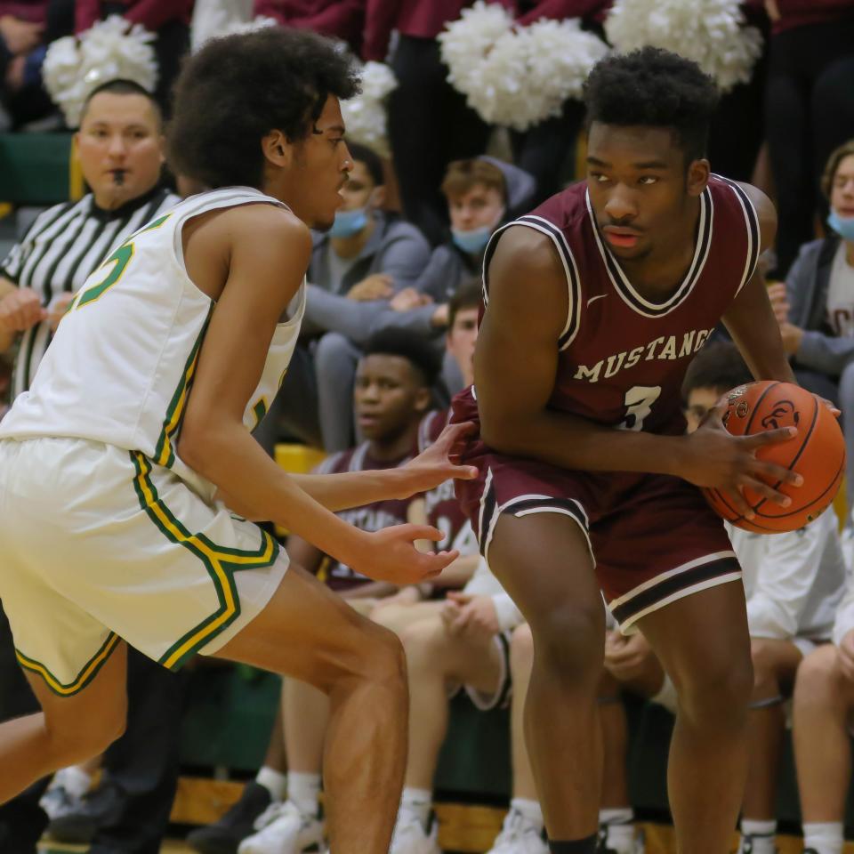 Salina Central's Freddy Ruffin (3) looks for an open teammate while being defended by Salina South's Quevon Purucker (25) during Friday's game at the South gym.