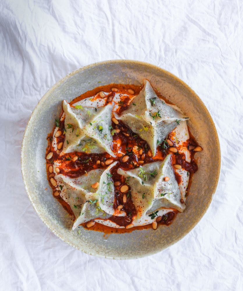 Vegan mushroom manti with tahini yogurt and tomato chile sauce served in a plate