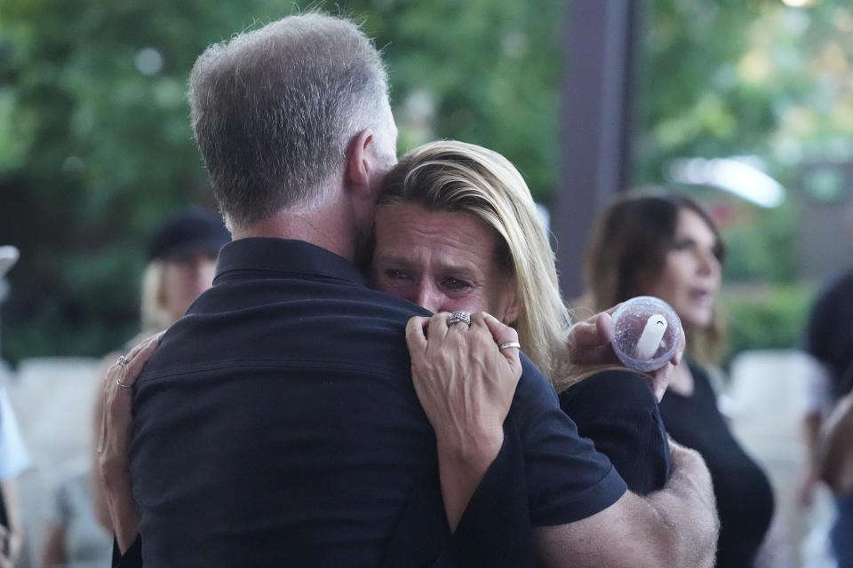 Members of the Trabuco Caynon community, Kevin Roberts hugs friend, Tara Donahue, both regulars of the Cook's Corner as they join a prayer vigil to help families cope with the Cook's Corner shooting tragedy at the Saddleback Church in Lake Forest, Calif., Friday, Aug. 25, 2023. (AP Photo/Damian Dovarganes)