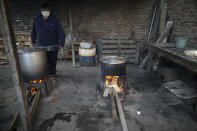 En esta imagen, tomada el 9 de junio de 2020, un voluntario vigila ollas al fuego en un comedor benéfico, durante la pandemia del coronavirus, a las afueras de Buenos Aires, Argentina. Argentina, uno de los mayores productores de alimentos del mundo, sufre además una creciente emergencia alimentaria. Daniel Arroyo, ministro de Desarrollo Social, dice a la AP que antes de la pandemia 8 millones de personas recibían alimentos, “y hoy tenemos 11 millones”. (AP Foto/Natacha Pisarenko)