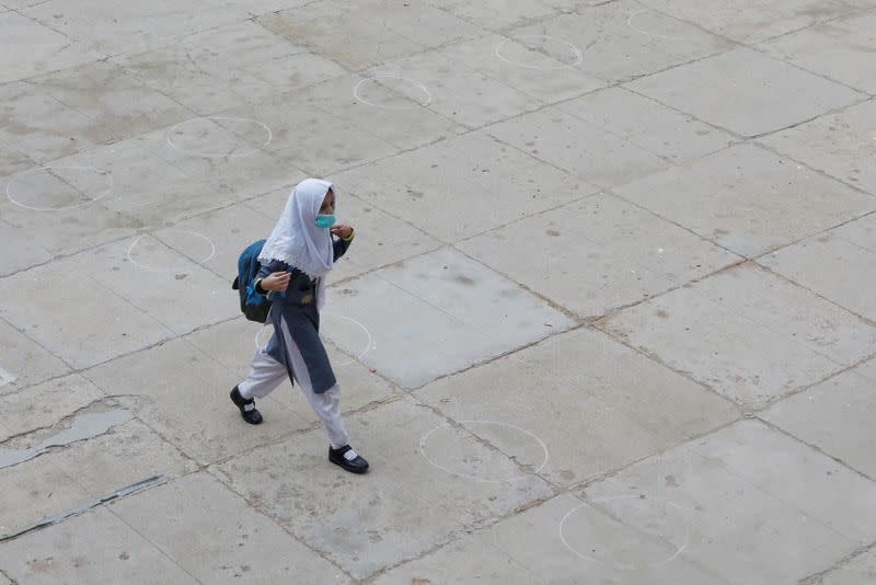 A student wearing protective mask walks over the marks for safe distancing as schools reopen amid the coronavirus disease (COVID-19) pandemic, in Karachi,