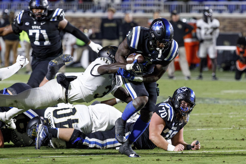 Duke's Jordan Waters (7), front right, carries the ball past Wake Forest's Malik Mustapha (3) during the first half of an NCAA college football game in Durham, N.C., Thursday, Nov. 2, 2023. (AP Photo/Ben McKeown)