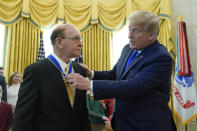 President Donald Trump awards the Presidential Medal of Freedom, the highest civilian honor, to Olympic gold medalist and former University of Iowa wrestling coach Dan Gable in the Oval Office of the White House, Monday, Dec. 7, 2020, in Washington. (AP Photo/Patrick Semansky)