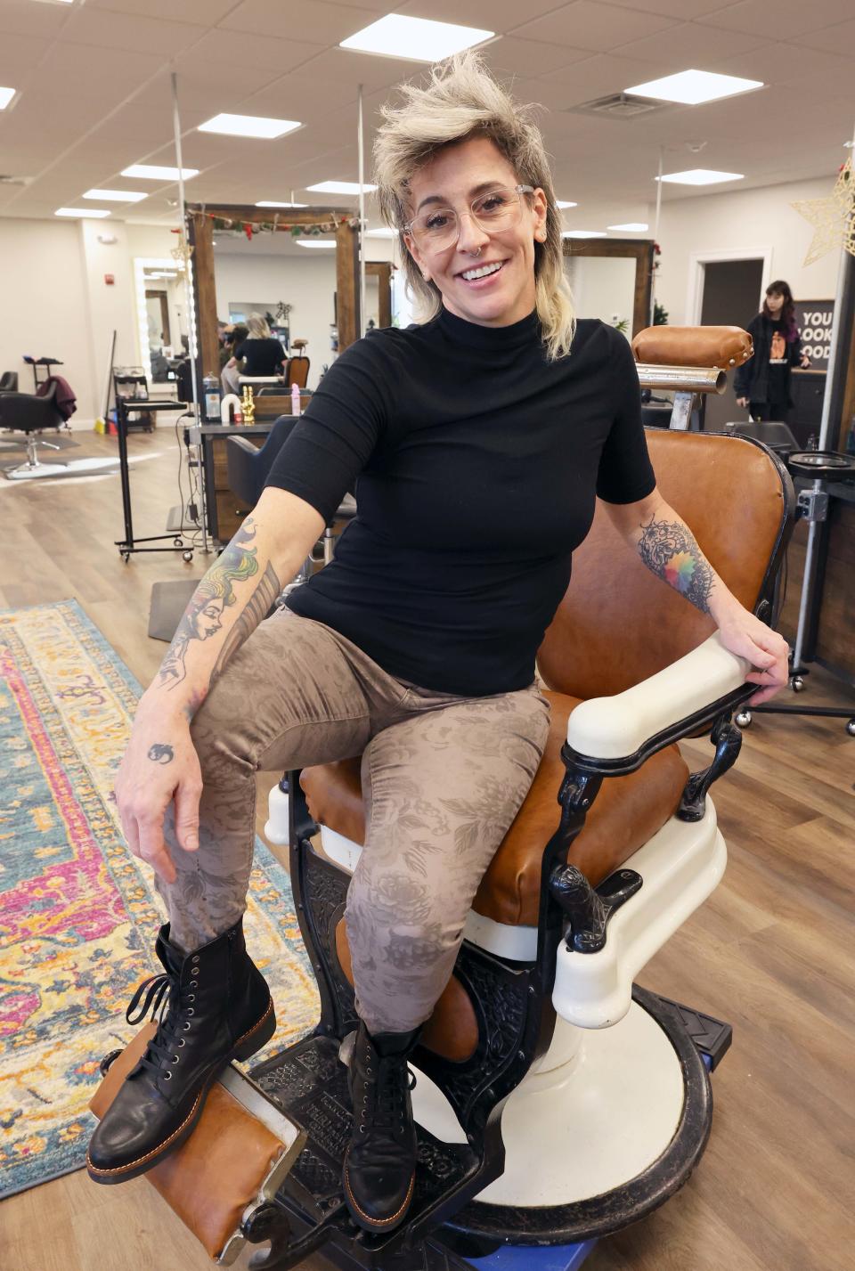 Missy Battaglia, owner of Revolutions Salons, sits in her grandfather's barber shop chair in the salon's new location at 15 Fireworks Circle, Bridgewater on Thursday, Dec. 8, 2022. Her grandfather, a Boston barber, was still cutting hair at the age of 92, she said.