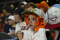 FILE - Fans watches before Game 1 of baseball's American League Championship Series between the Houston Astros and the Boston Red Sox on, Oct. 15, 2021, in Houston. Even if baseball’s first work stoppage in 26 years doesn’t result in missed games, the league and its players are at risk of alienating their next wave of fans. (AP Photo/David J. Phillip, File)