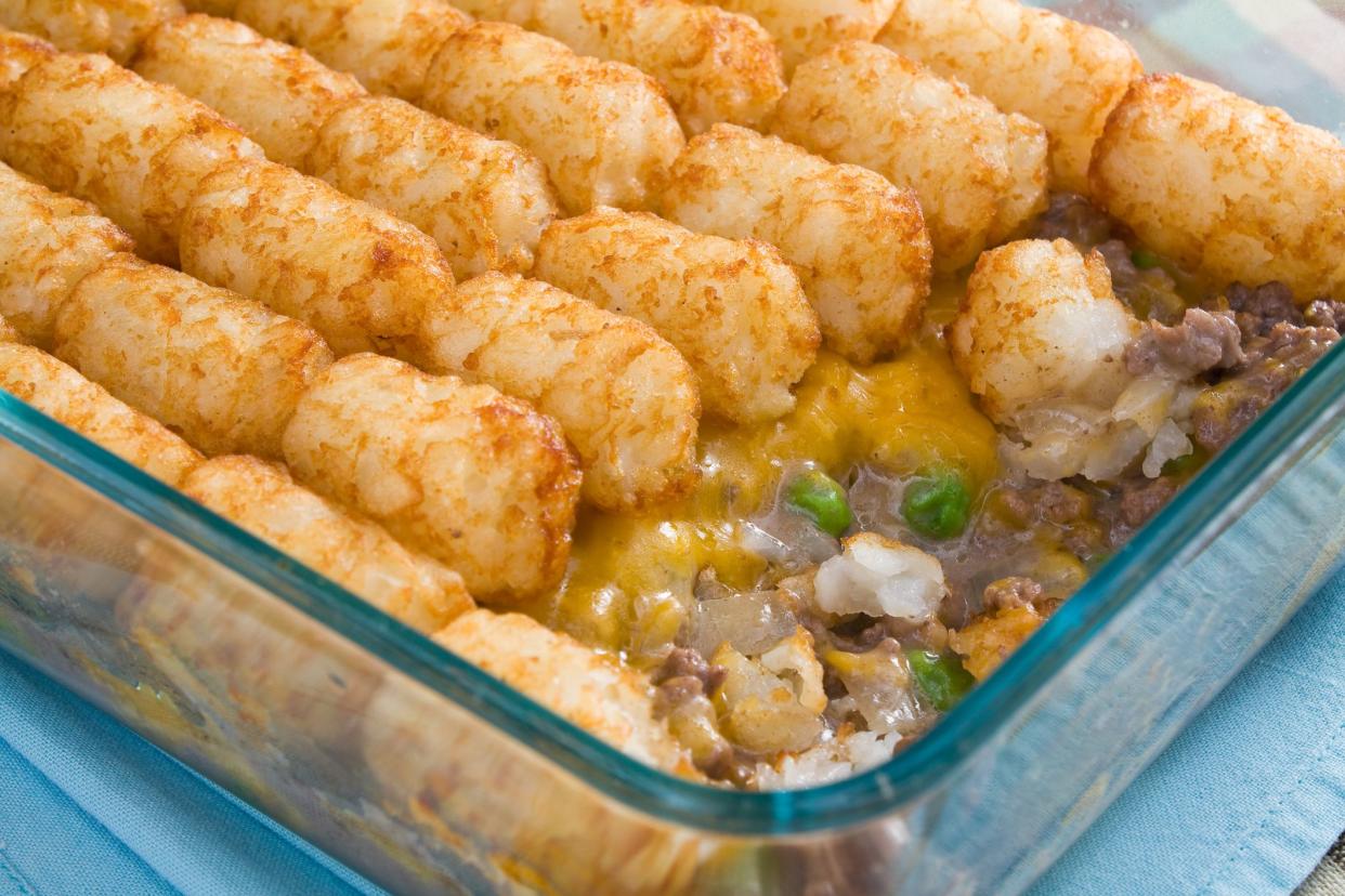 Casserole made of tater tots, cheddar cheese, ground beef, peas, and onions.