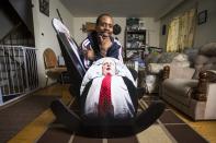 Luanga Nuwame poses on his " Mayor Rob Ford Crack Rocker", a rocking chair made completely of cardboard materials with pictures of the embattled Toronto Mayor Rob Ford on the back and sides, in Mississauga December 12, 2013. Nuwame, also known as the "Homemade Game Guru", is an artist who creates things made of cardboard, was inspired to make the chair after Ford admitted early last month he had smoked crack cocaine, saying it was probably "in one of my drunken stupors," but he has said he is not an addict. REUTERS/Mark Blinch (CANADA - Tags: POLITICS SOCIETY)