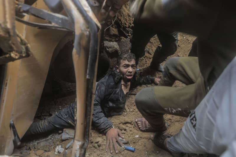 Palestinians rescue a survivor out of the rubble, following an Israeli strike on Rafah in the southern Gaza Strip. Mohammed Talatene/dpa