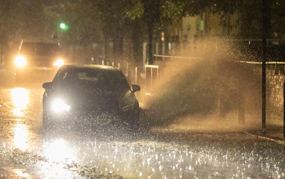 Vehicles make a large splash as they travel through Greenwich in the early hours of Monday