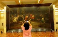 A tourist takes a photograph of the restored painting "Spoliarium", at the National Museum in Manila in June 2011. Flash camera-toting tourists could wreck the Philippines' greatest work of art, say the worried curator of the "Spoliarium", a symbol of Filipino awakening against Spain's colonial yoke