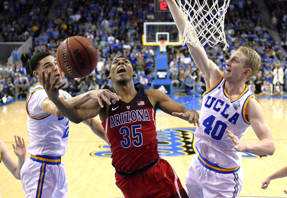 Arizona guard Allonzo Trier, center, shoots as UCLA guard Lonzo Ball, left, and center Thomas Welsh defend during the second half of an NCAA college basketball game, Saturday, Jan. 21, 2017, in Los Angeles. Arizona won 96-85. (AP Photo/Mark J. Terrill)