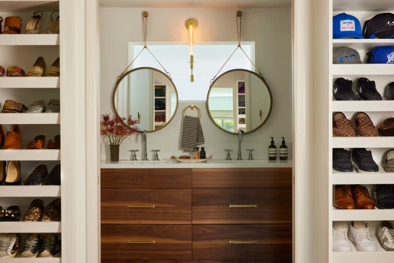 Double vanity with matching round mirrors and matching built in shoe shelves