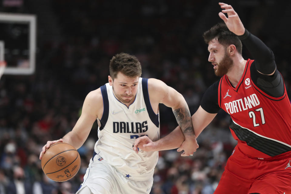 Dallas Mavericks guard Luka Doncic drives past Portland Trail Blazers center Jusuf Nurkic during the first half of an NBA basketball game in Portland, Ore., Wednesday, Jan. 26, 2022. (AP Photo/Amanda Loman)