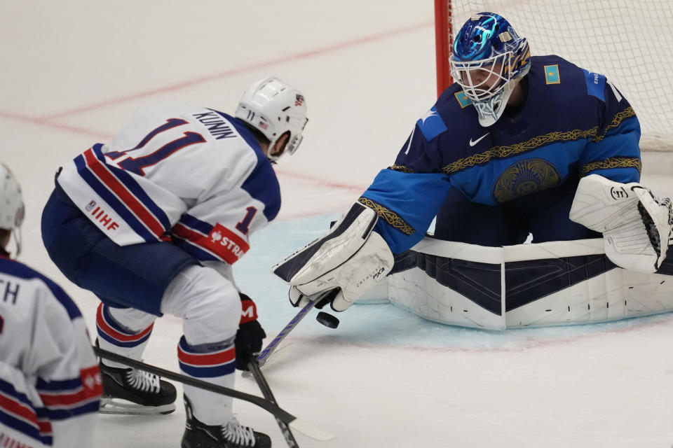 Kazakhstan's goalkeeper Nikita Boyarkin, right, makes a save in front of Unted States' Luke Kunin during the preliminary round match between United States and Kazakhstan at the Ice Hockey World Championships in Ostrava, Czech Republic, Sunday, May 19, 2024. (AP Photo/Darko Vojinovic)