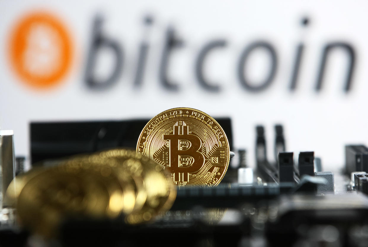 Bitcoin cryptocurrency coins and a PC motherboard are pictured in Kyiv on 19 July, 2021.  (Photo by STR/NurPhoto via Getty Images)