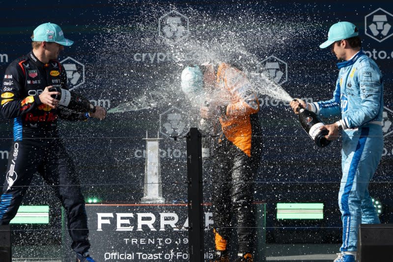 Max Verstappen (L) and Charles Leclerc (R) spray champagne on fellow Formula 1 driver Lando Norris during the podium ceremony for the Miami Grand Prix on Sunday at the Miami International Autodrome in Miami Gardens, Fla. Photo by Greg Nash/UPI