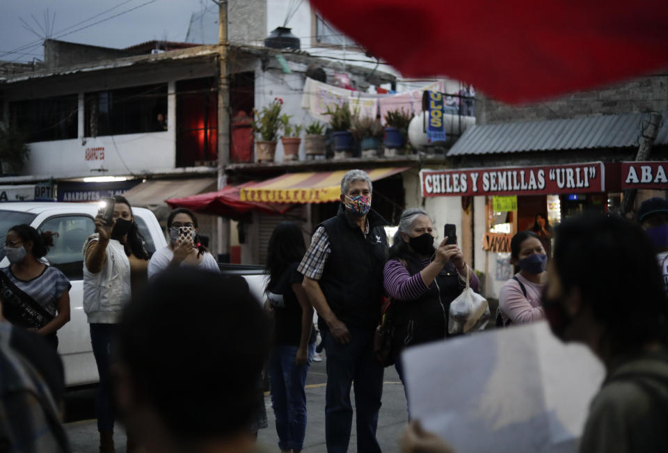 Residents watch a march demanding justice for the people who died in Monday's subway collapse, in Mexico City's south side, Friday, May 7, 2021. An elevated section of Line 12 collapsed late Monday killing at least 25 people and injuring more than 70, city officials said. (AP Photo/Eduardo Verdugo)