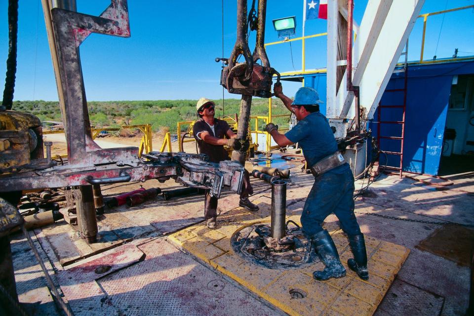 Petroleum Workers Moving a Drill