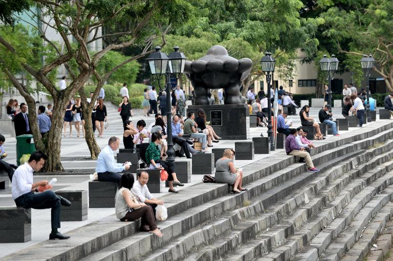 Office workers sit along the quay at Raffles Place financial district in Singapore on January 14, 2014