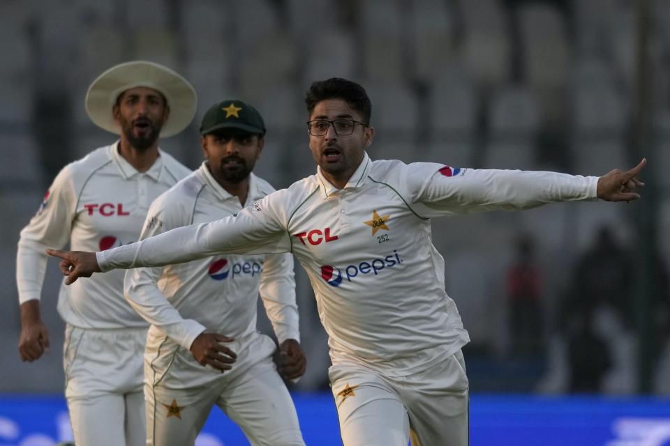 Pakistan's Abrar Ahmed, front, celebrates after taking the wicket of England's Zak Crawley during the first day of third test cricket match between England and Pakistan, in Karachi, Pakistan, Saturday, Dec. 17, 2022. (AP Photo/Fareed Khan)