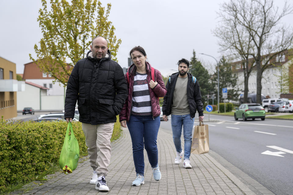 Asylum seeker go back to the refugee shelter after shopping, in Eichsfeld, Germany, Wednesday, April 24, 2024. Across Germany, cities and counties are introducing new payment cards for asylum-seekers. The new rule, which was passed by parliament last month, calls for the migrants to receive their benefits on a card that can be used for payments in local shops and services. (AP Photo/Ebrahim Noroozi)