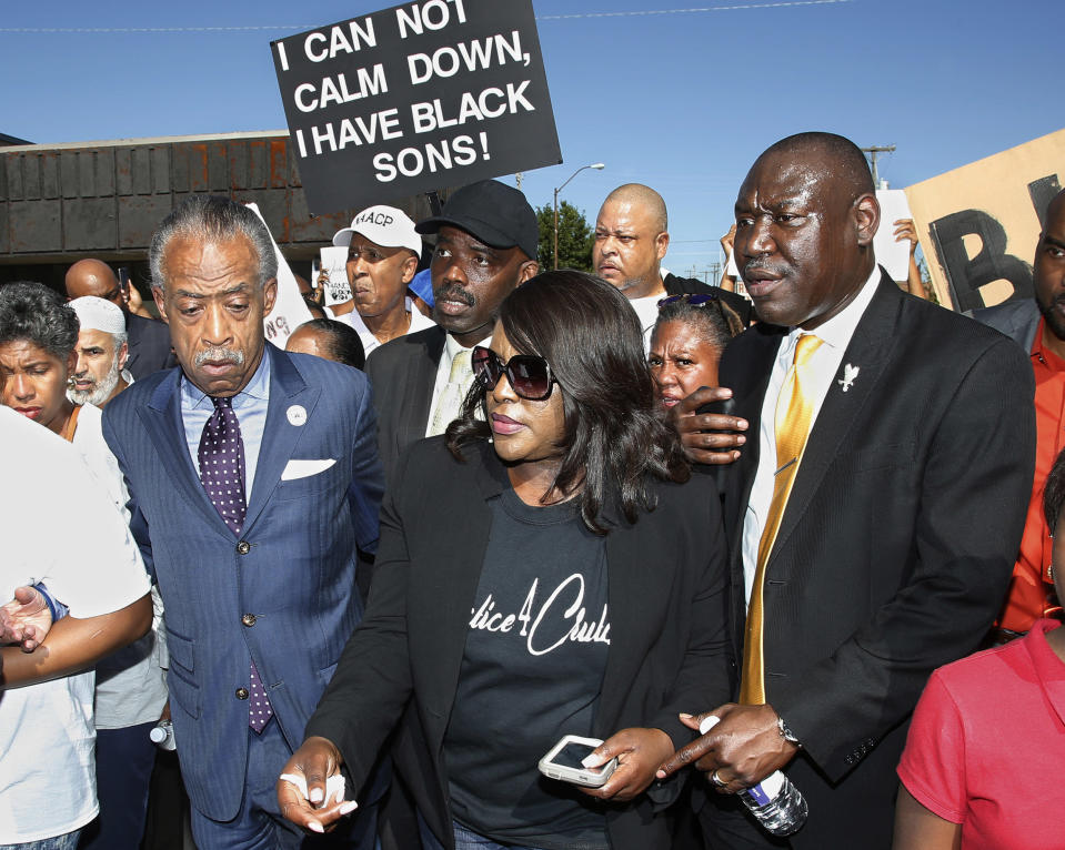 Tiffany Crutcher, center, the twin sister of Terence Crutcher, who was killed by a Tulsa police officer, marches with the Rev. Al Sharpton, left, and attorney Benjamin Crump, right, in Tulsa, Okla., on Sept. 27, 2016. (Sue Ogrocki / AP file)