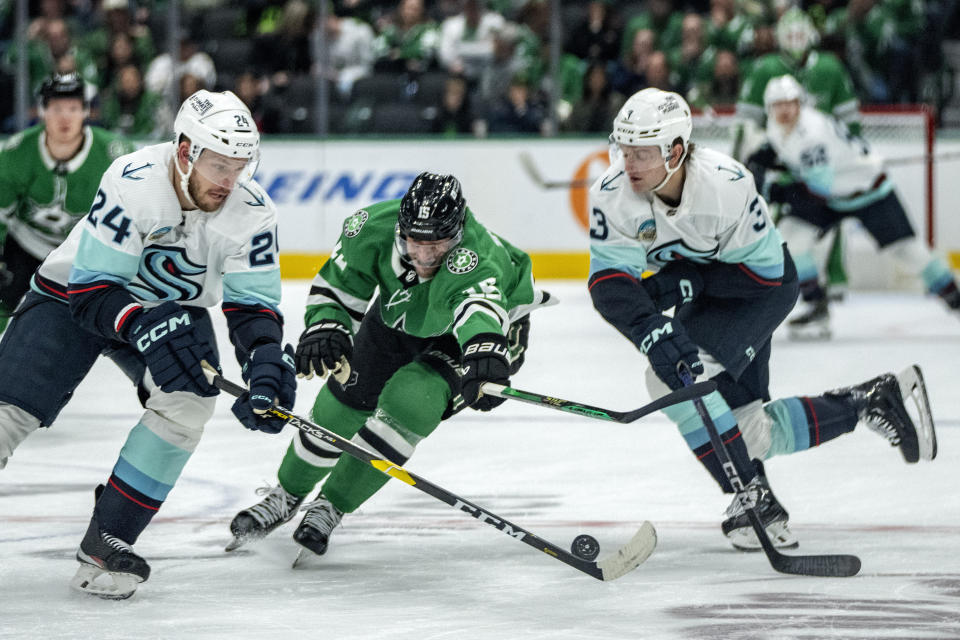 Dallas Stars center Craig Smith (15) competes for the puck with Seattle Kraken defensemen Jamie Oleksiak (24) and Will Borgen (3) during the first period of an NHL hockey game Monday, Dec. 18, 2023, in Dallas. (AP Photo/Jeffrey McWhorter)