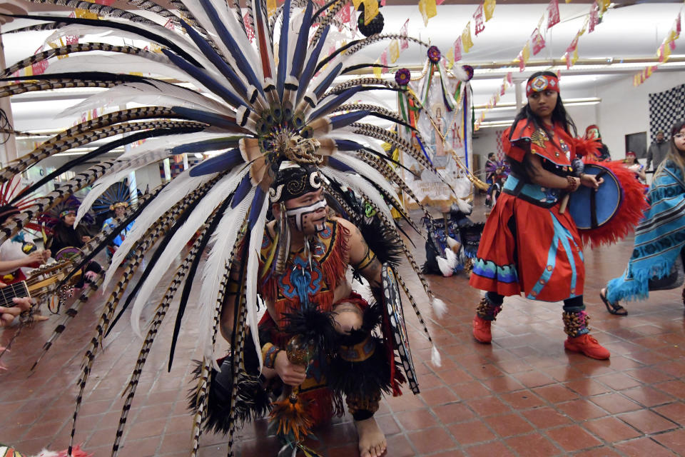 In this Jan. 24, 2020 photo, people in Aztec clothing take part in a dance at the Sagrado Corazon de Jesus church in Minneapolis for a two-day celebration of St. Paul, the patron saint of their Mexican hometown of Axochiapan and nearby villages in the state of Morelos. The celebration is a way to recognize their roots and feel closer to the families and home they left behind. (AP Photo/Jim Mone)