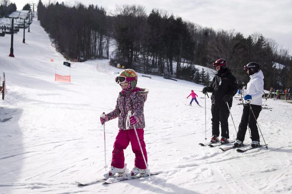 Maureen and Rob Dennis ski to the chairlift with their daughter Alia at the Mansfield Ski Resort north of Toronto in this Feb. 2016 photo. Deep snow and a cheap currency are lifting optimism for a blizzard of profits at Canadian ski destinations this year. 