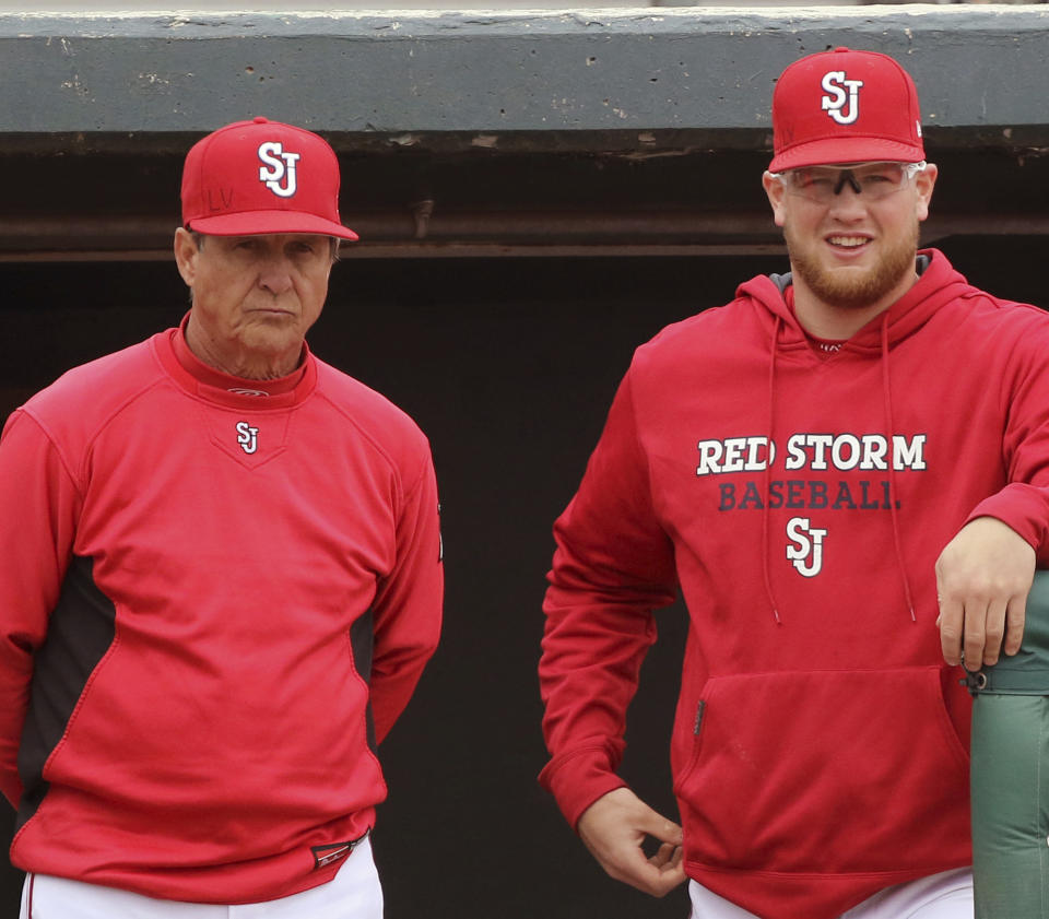 FILE - In this March 25, 2017, file photo, St. John's NCAA college baseball head coach Ed Blankmeyer, left, and pitcher Jeff Belge watch from the dugout during a game against Maine in New York. Blankmeyer went into this season expecting his St. John's baseball team to get off to a solid start. But not even the veteran coach could have predicted the Red Storm to roll quite like this. They're soaring up the national polls at 18-2, their best start since the 1981 squad that featured future major leaguers Frank Viola and John Franco opened 26-1. (AP Photo/Gregory Payan, File)