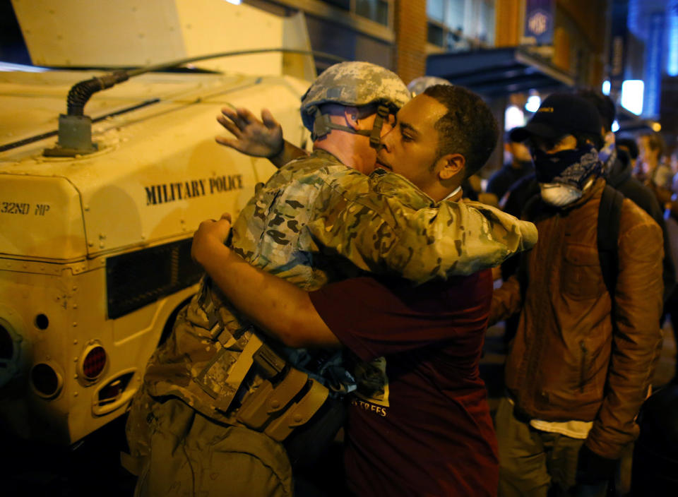 A U.S. National guard soldier accepts a hug from protester as people march through downtown to protest the police shooting of Keith Scott in Charlotte, North Carolina