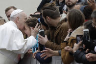 Pope Francis kisses a child in St. Peter's Square at the Vatican before leaving after his weekly general audience, Wednesday, Feb. 26, 2020. (AP Photo/Alessandra Tarantino)