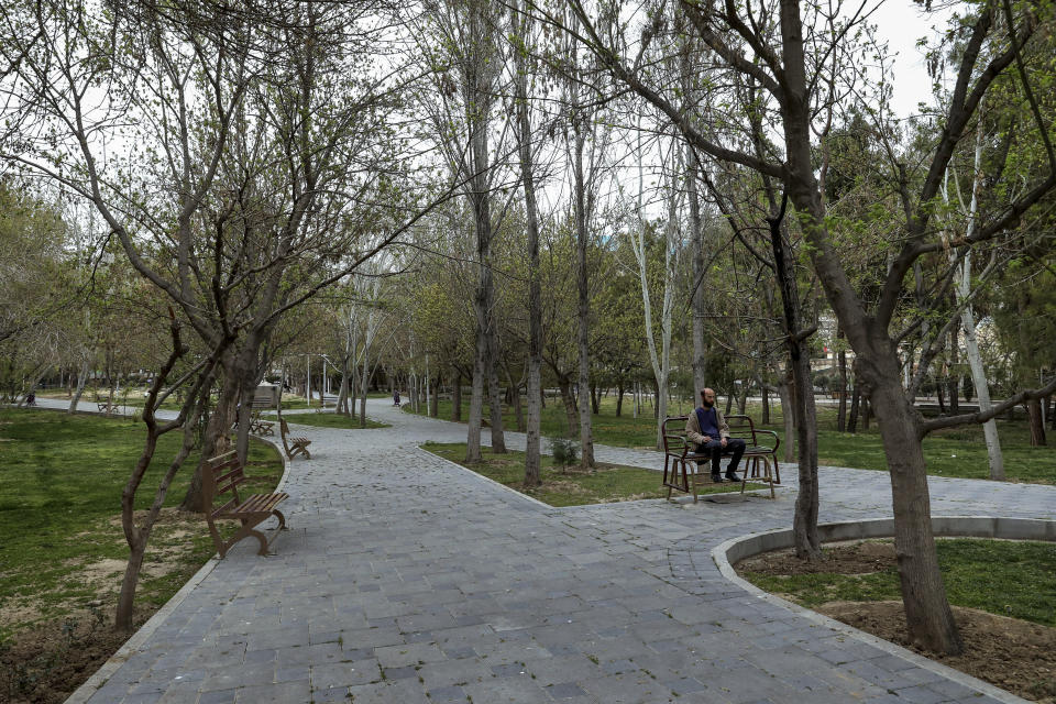 In this March 18, 2020 photo, a man sits alone in an empty park in Tehran, Iran. The typically frenetic streets of Iran’s capital, Tehran, have fallen silent and empty due to the new coronavirus outbreak that’s gripped the Islamic Republic. (AP Photo/Ebrahim Noroozi)