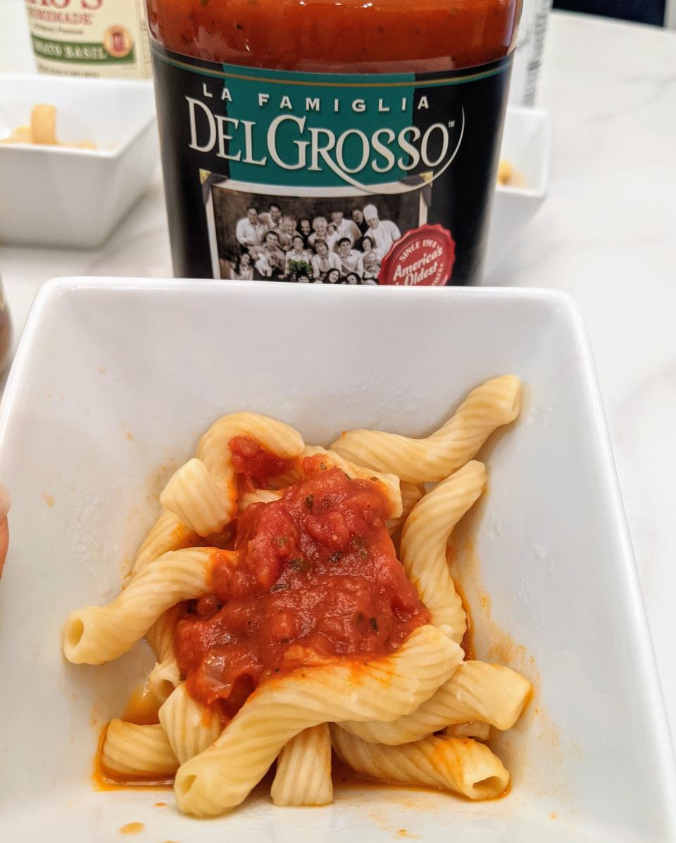 jar of delgrosso red sauce behind a small white bowl of pasta