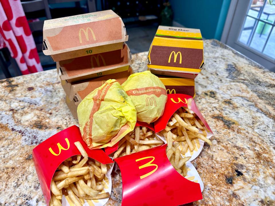 Mcdonald's fries, burgers, and nuggets stacked on a. table 