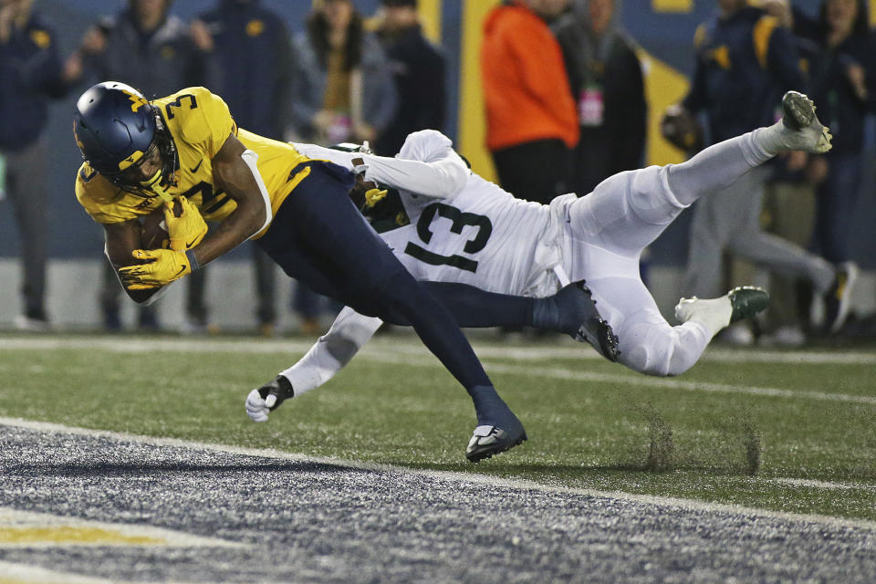 West Virginia wide receiver Kaden Prather (3) scores a touchdown as Baylor safety Al Walcott (13) defends during the second half of an NCAA college football game in Morgantown, W.Va., Thursday, Oct. 13, 2022. (AP Photo/Kathleen Batten)