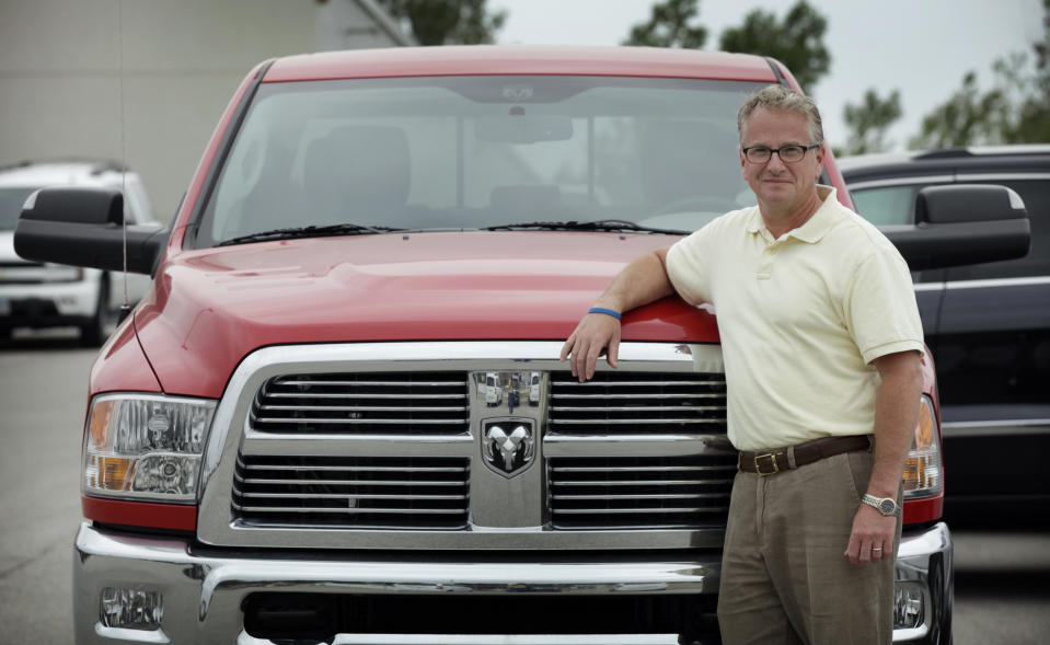 In this Wednesday, June 20, 2012 photo, Mark Beardmore leans on the front of a pickup truck at the auto dealership where he works in Carroll, Iowa. "Government needs to stay out of more things rather than infuse itself in more things," says Beardmore, a county commissioner whose stance might seem unlikely since he’s a Chrysler salesman. Though the automaker was on the brink of collapse before a government rescue, he's convinced it would have survived, maybe with an investment from China or another foreign country. Beardmore also thinks the move won the president political points. "I think Mr. Obama went to bed saying I've got to do something to save these jobs," he says. "I don't think he was laying his head on the pillow saying I've got to appease the unions. I think that was a side benefit." (AP Photo/Charlie Neibergall)