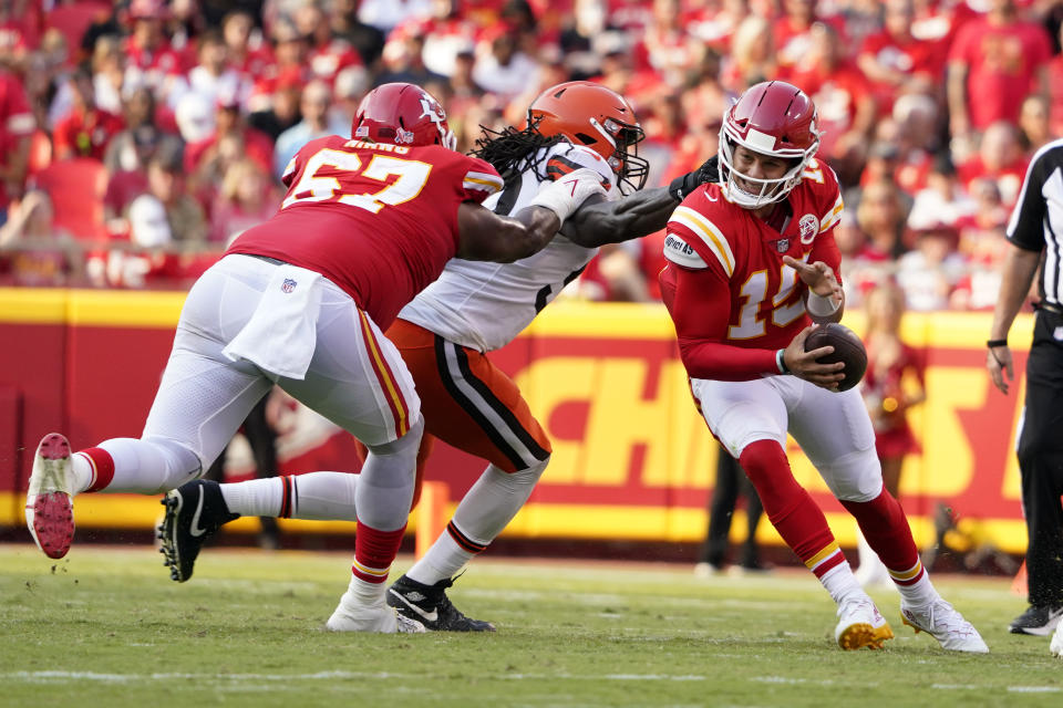 Kansas City Chiefs quarterback Patrick Mahomes, right, slips away from Cleveland Browns defensive end Jadeveon Clowney as Chiefs offensive tackle Lucas Niang (67) blocks during the second half of an NFL football game Sunday, Sept. 12, 2021, in Kansas City, Mo. (AP Photo/Ed Zurga)