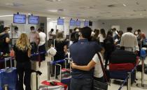 FILE - In this April 17, 2021, file photo, people check in for a flight to Miami at Silvio Pettirossi Airport, in Luque, Paraguay. Vaccine seekers who can afford to travel are coming to the United States to avoid the long wait, including people who have come from as far as Paraguay. (AP Photo/Jorge Saenz, File)