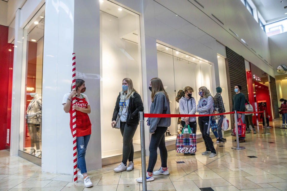 Customers lined up outside of a Bath and Body Works store