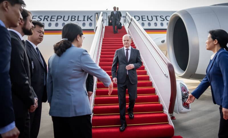 German Chancellor Olaf Scholz (C) gets off the plane at Chongqing Airport in China and is greeted by Zhang Guozhi, Vice Mayor of Chongqing City. Scholz's trip to Chongqing, Shanghai and Beijing will focus on economic relations with the world's second-largest economy, the war in Ukraine, the conflict over Taiwan and the human rights situation in China. Michael Kappeler/dpa