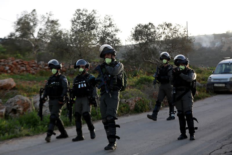 Israeli border police members wear masks as they walk during a Palestinian protest against Israeli settlements, near the town of Beita in the Israeli-occupied West Bank