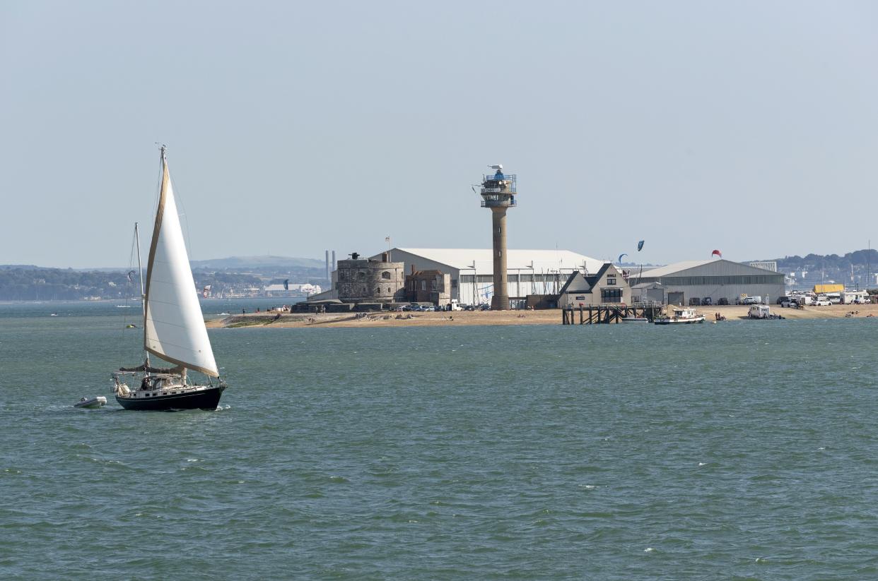 Sailing boat passing Calshot Activities center on the shores of the Solent, Calshot Spit, Southampton, England UK. (Photo by: Education Images/Universal Images Group via Getty Images)