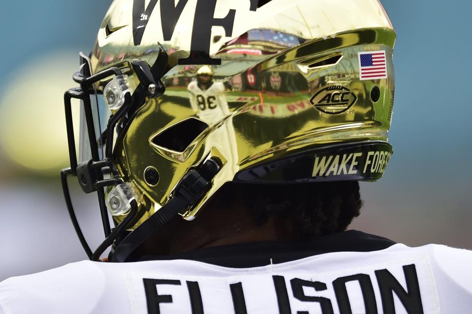 Wake Forest Demon Deacons running back Justice Ellison (14) looks on before the game as teammate wide receiver Nick Ragano (38) is reflected in his helmet Friday, Dec. 31, 2021 at TIAA Bank Field in Jacksonville. The Wake Forest Demon Deacons and the Rutgers Scarlet Knights faced each other in the 2021 TaxSlayer Gator Bowl. [Corey Perrine/Florida Times-Union]