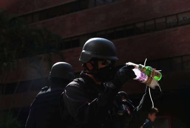 Members of a safety team established by police and local authorities hold up what is believed to be a molotov cocktail, at the Hong Kong Polytechnic University (PolyU) in Hong Kong, China